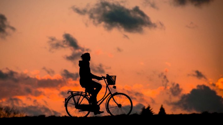 person riding a bike at sundown